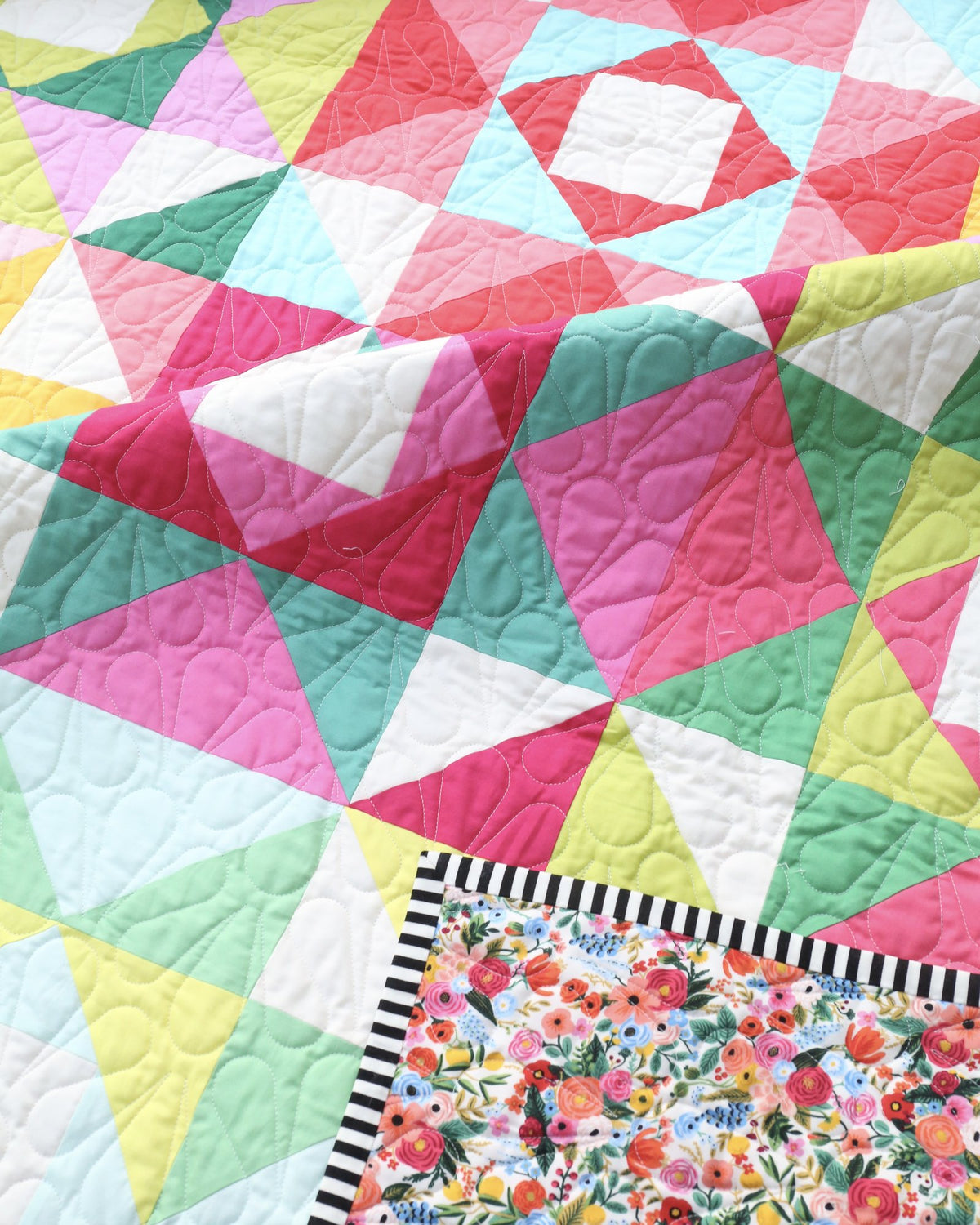 Economy Stars quilt corner with floral backing and black and white striped binding