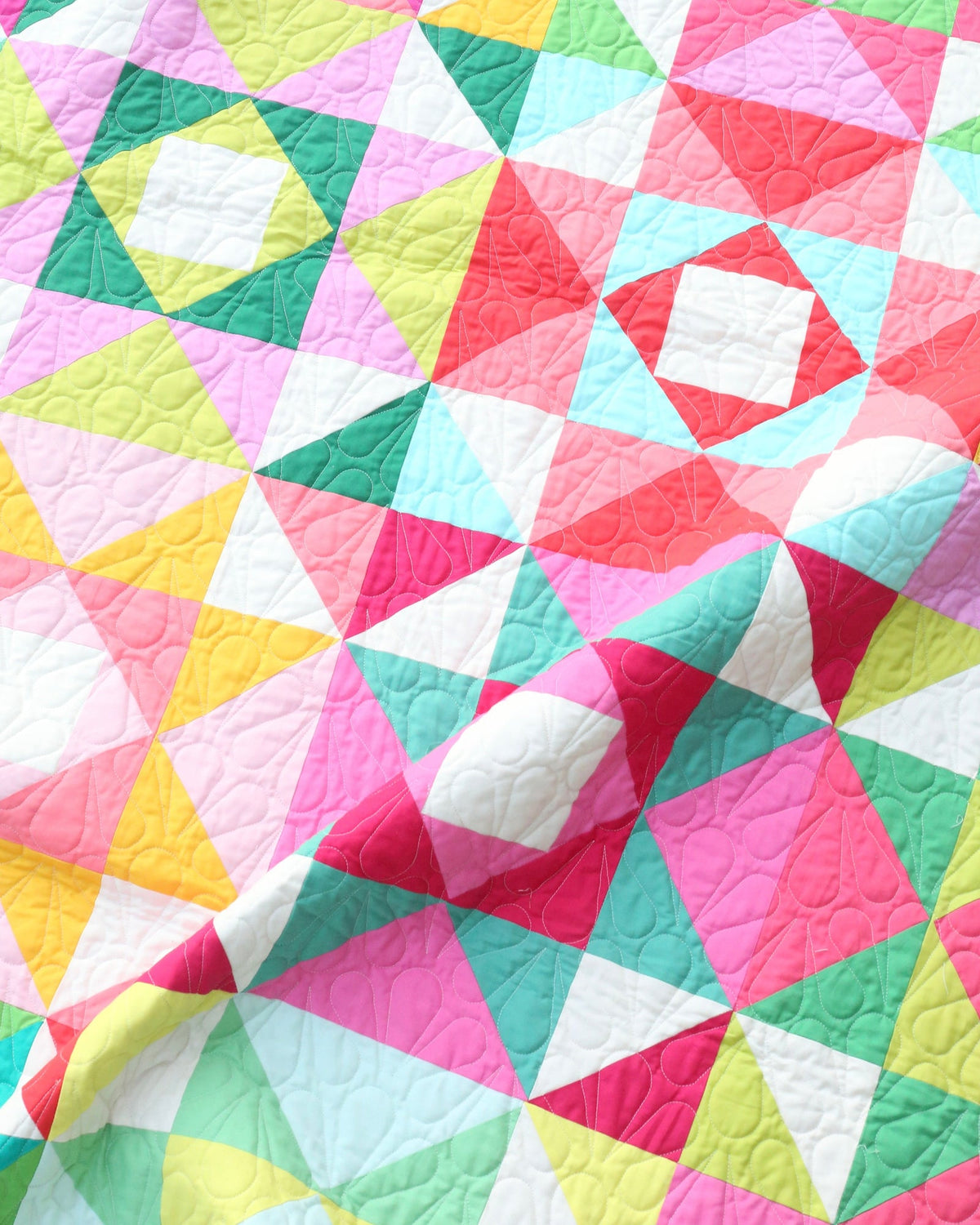 Close-up of bright scrappy sawtooth stars with economy block centers